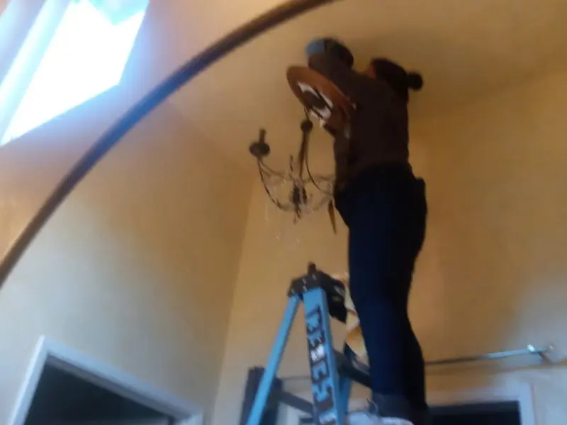 Electrician installing a chandelier in a Oneida residence